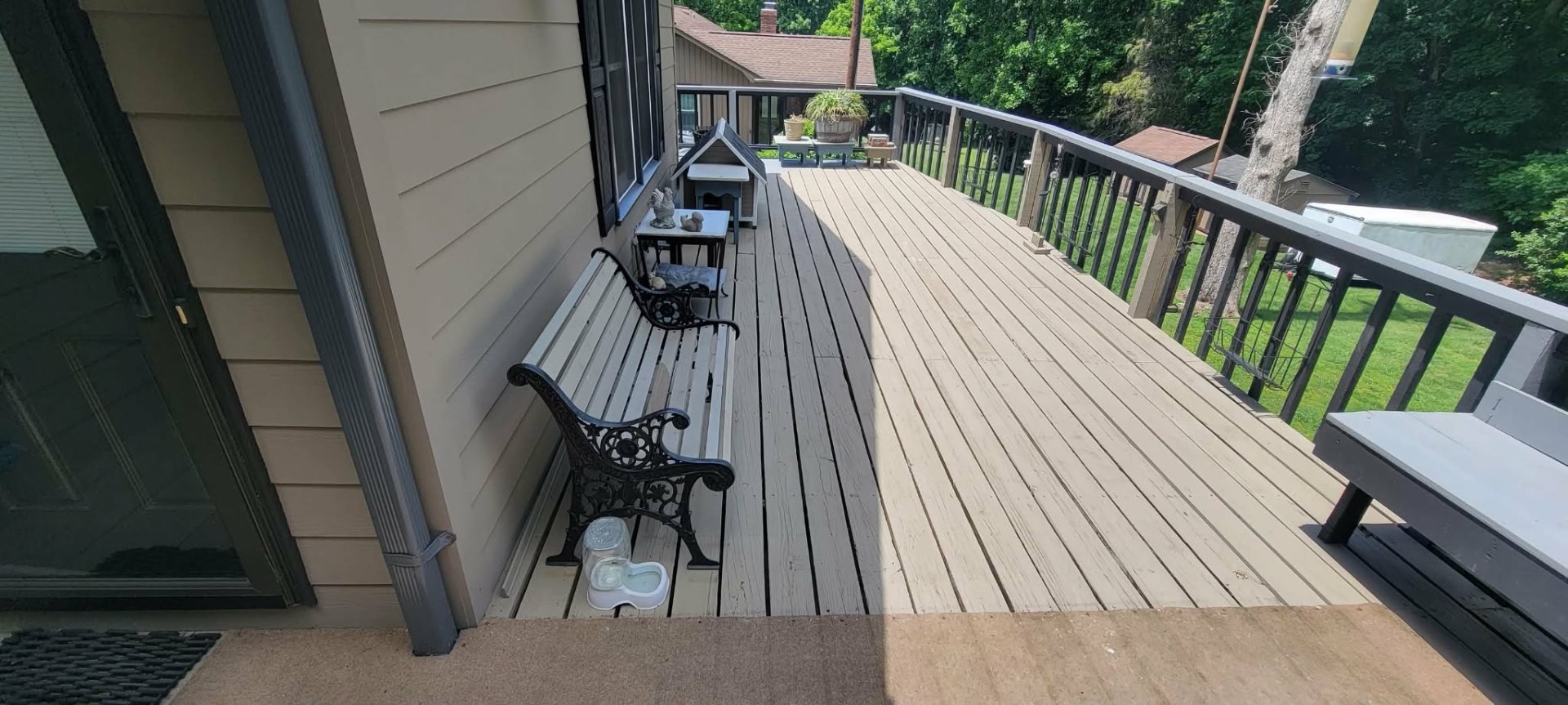 Long composite deck along side of home with bench seating