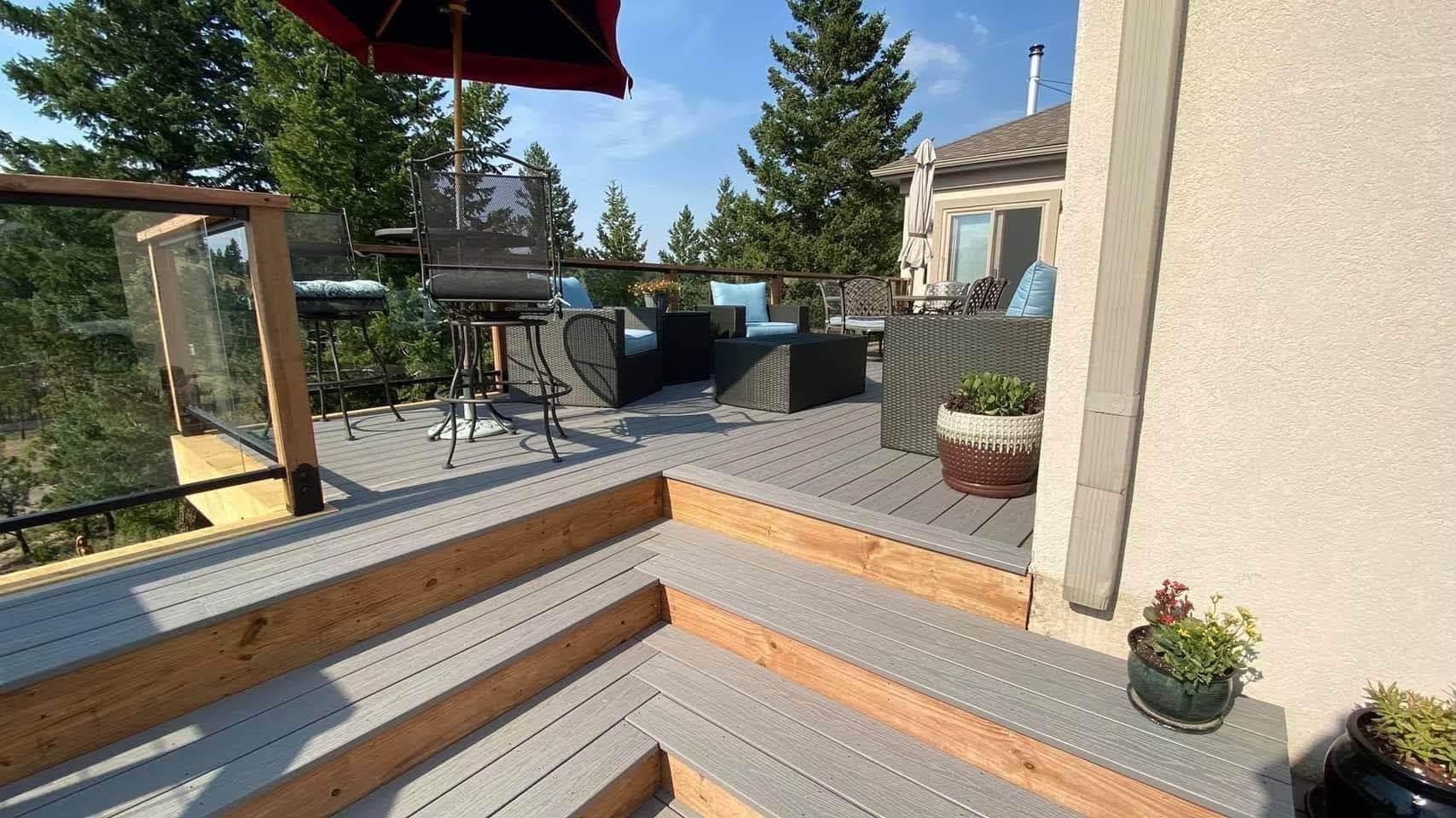 Multi-level composite deck with glass railing and mountain views