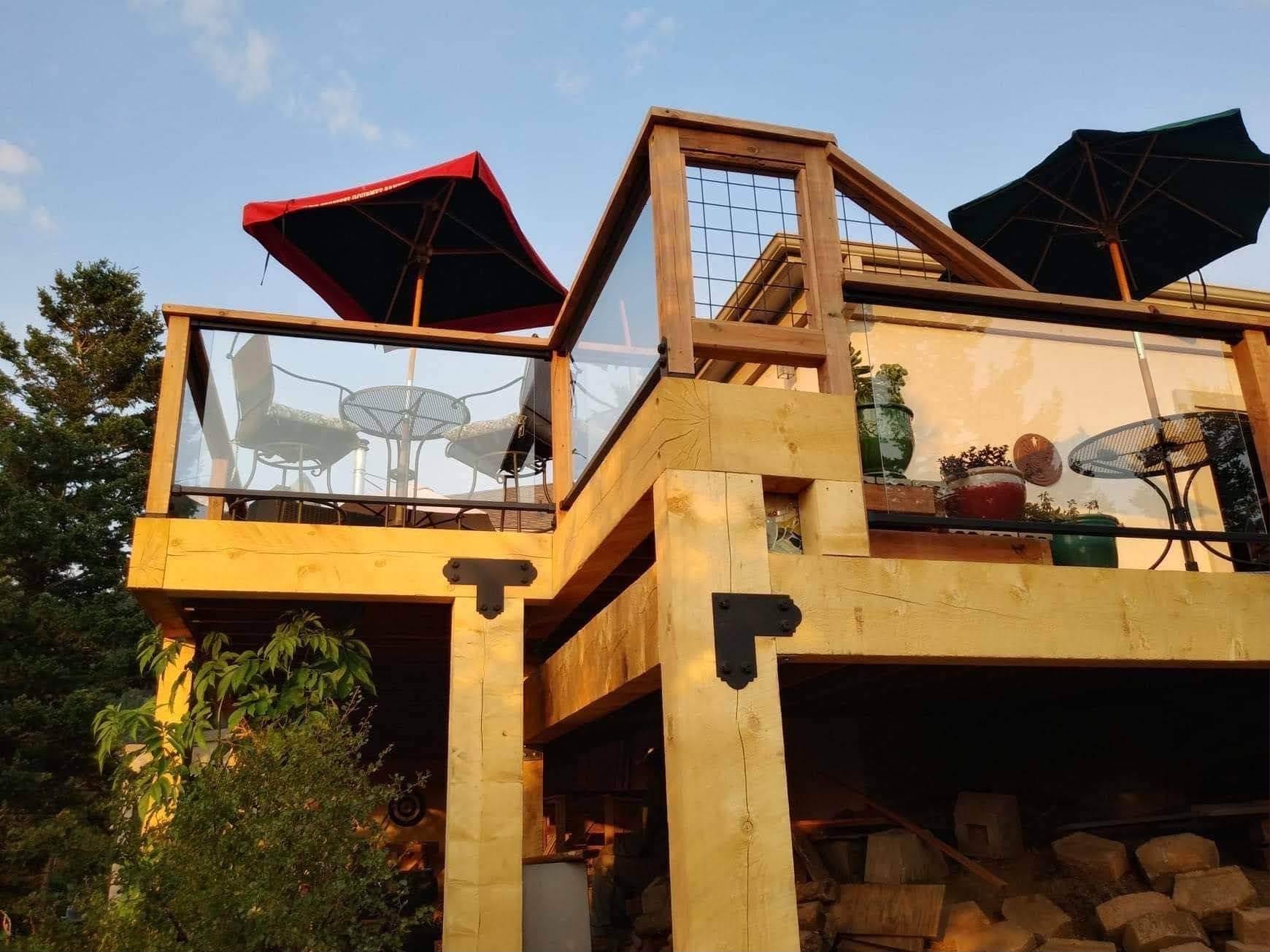 Custom timber-frame deck with heavy beams, glass rails and steel brackets