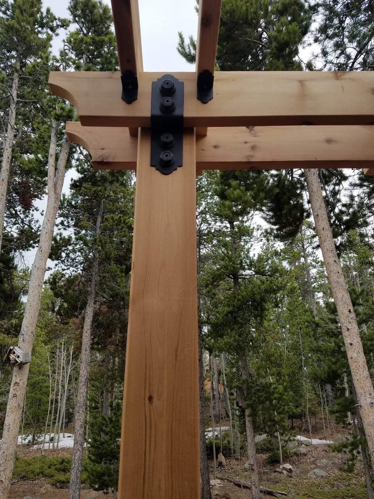 Custom cedar pergola beam detail with black steel bracket hardware