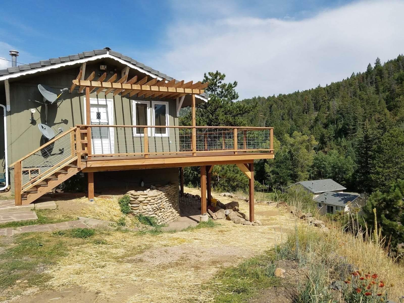 Elevated cedar deck with pergola and cable railing on hillside